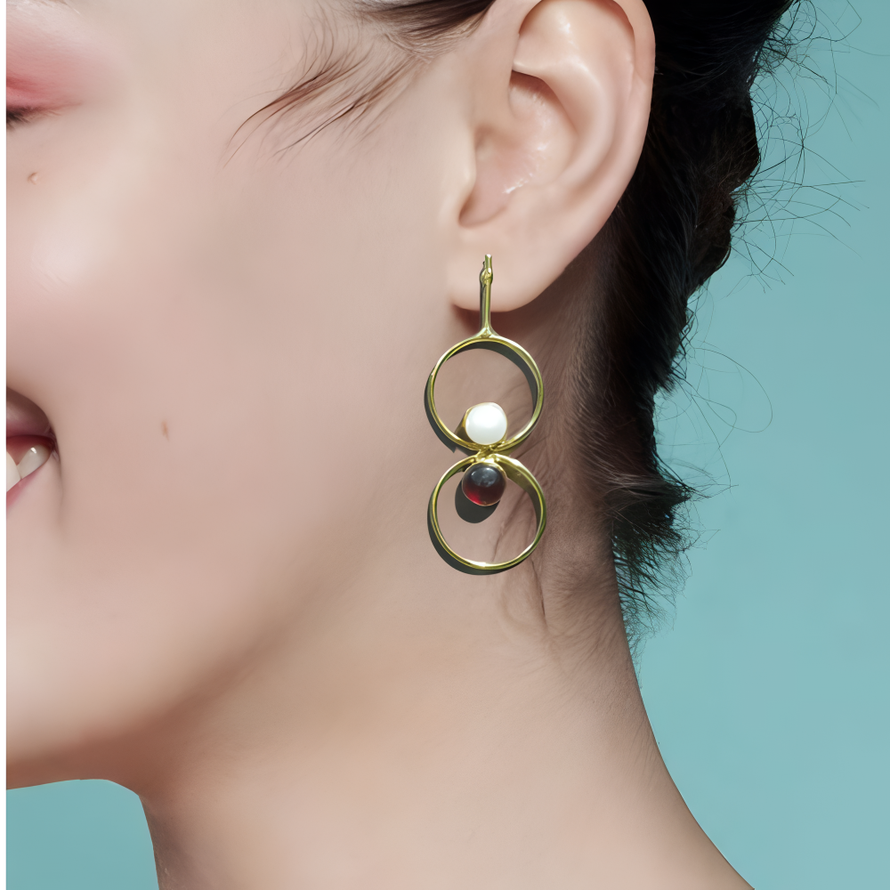 Gold earrings with circular design with pearl & stone worn by a model 