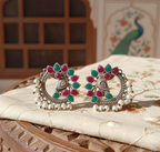 Multicolor peacock stud earrings with intricate detailing.